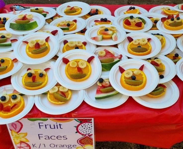 Multiple plates of animal faces made by the students using pieces of fruit.