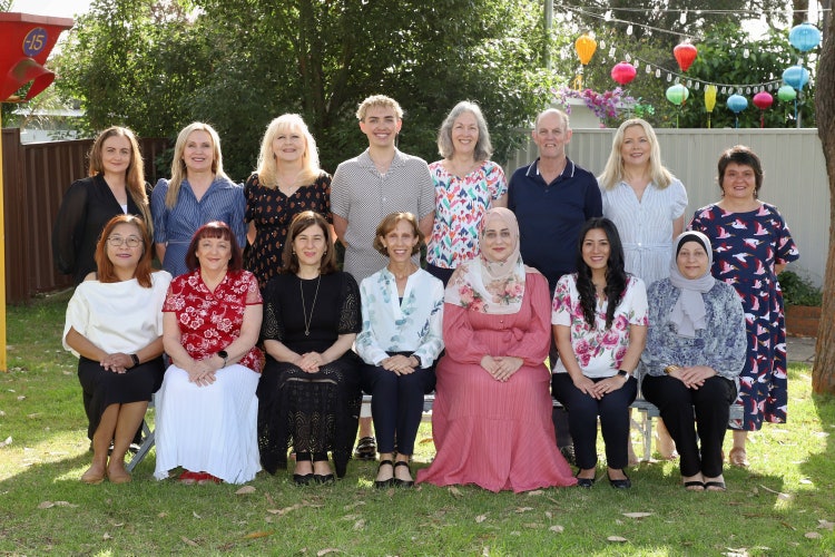 Sefton Infants School outdoor staff photo with 15 staff members.