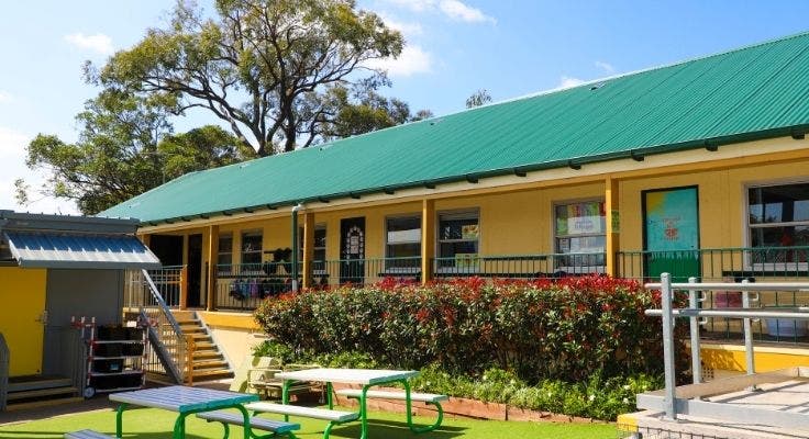 A Sefton Infants School building and part of playground with picnic tables.