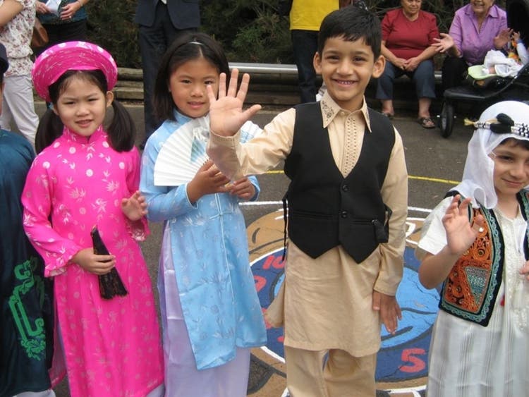 Four students wearing a range of traditional costumes from different countries.
