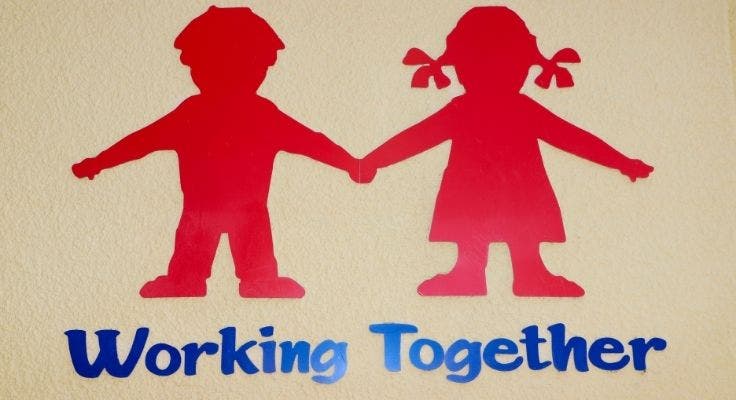 The school logo of two silhouettes of children holding hands and motto of 'Working Together.'