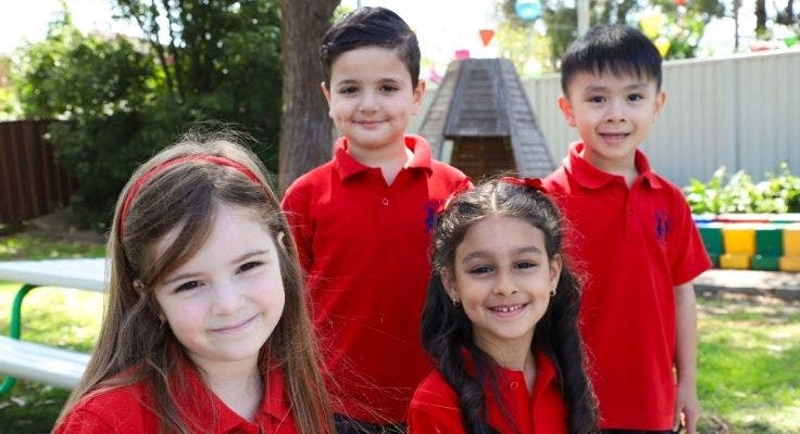 Two male and two female Kindergarten students posing for camera.