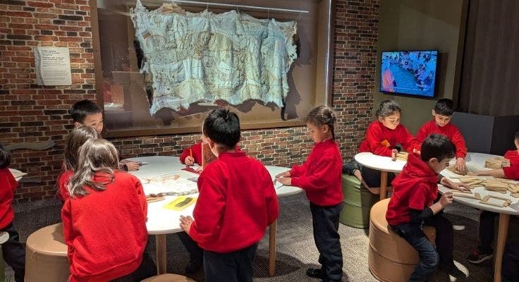 Eight students investigating artefacts at the museum.