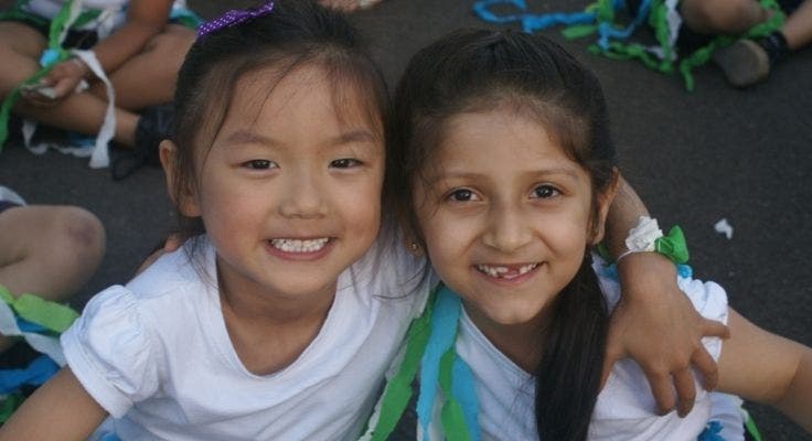 Two girls in concert outfits smiling.
